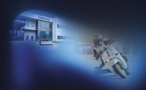 SINPRO co-brand banner: SINPRO headquarters building beside a racing motorcyclist on track